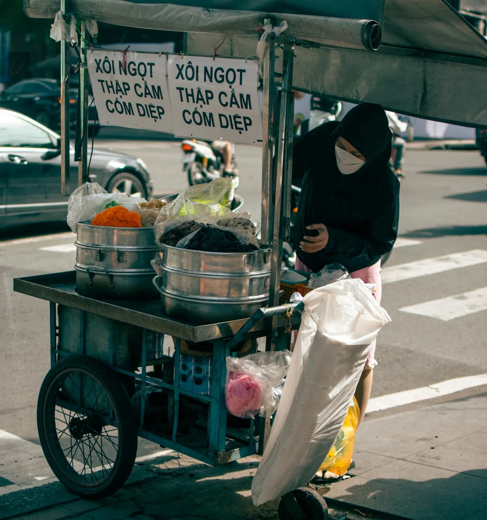 Carrito de comida callejera con ollas de vapor sobre una calle